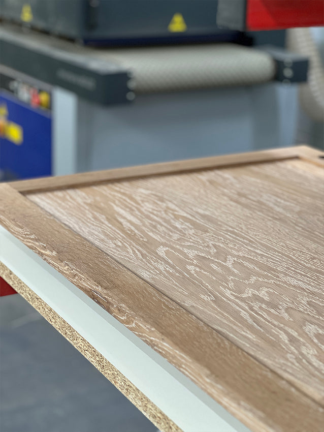 A rustic white oil being applied to oak wardrobe doors - all made possible by the brushing machine in the background